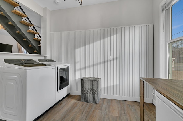 washroom featuring washer and dryer, laundry area, and wood finished floors