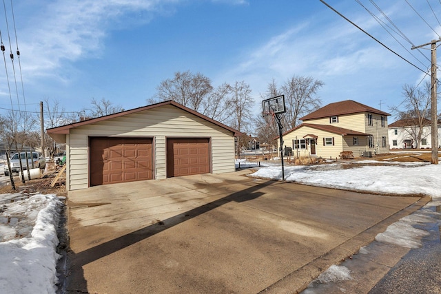 snow covered garage with a detached garage