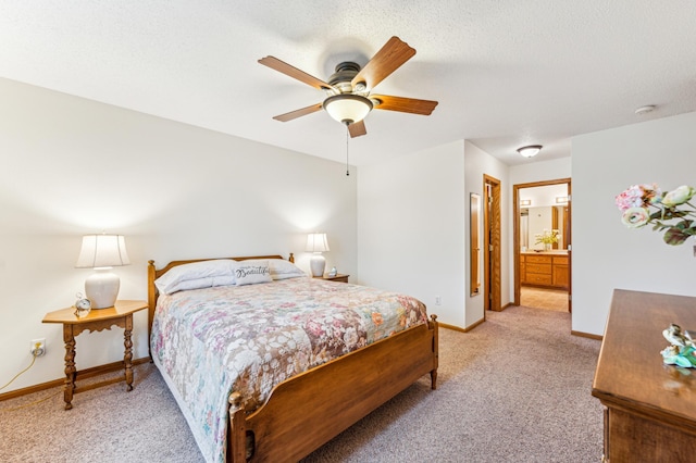 bedroom with ensuite bathroom, ceiling fan, a textured ceiling, light colored carpet, and baseboards