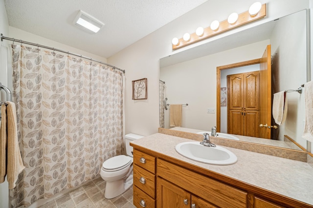 bathroom featuring vanity, toilet, and a textured ceiling