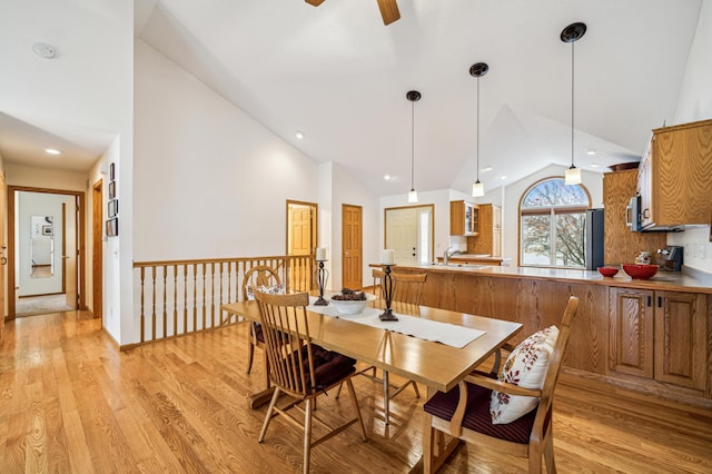 dining area with high vaulted ceiling, recessed lighting, light wood-style flooring, and a ceiling fan