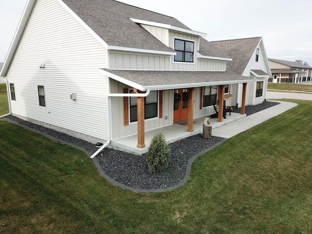 back of house featuring a lawn and a porch