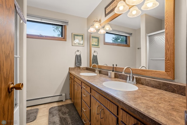 bathroom featuring a baseboard heating unit, vanity, a healthy amount of sunlight, and tile patterned floors