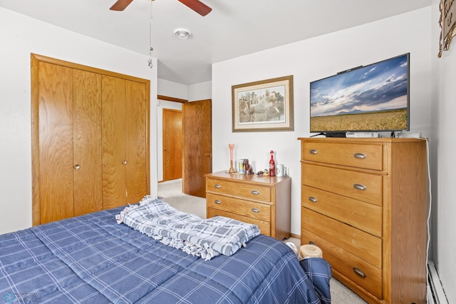 carpeted bedroom with a baseboard radiator, a closet, and ceiling fan