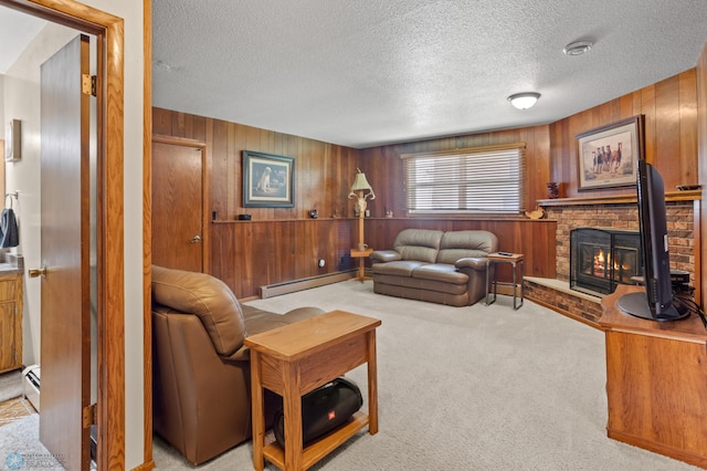 living room featuring a fireplace, a baseboard heating unit, a textured ceiling, light carpet, and wooden walls