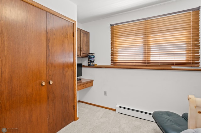 office with a baseboard radiator, light carpet, and built in desk