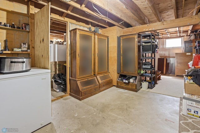 basement featuring refrigerator and electric panel