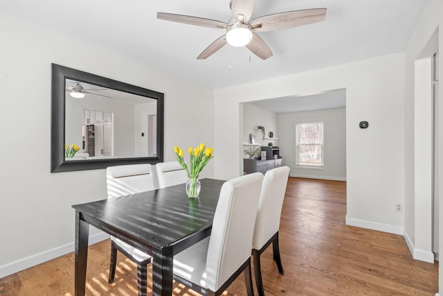 dining area with baseboards, ceiling fan, and wood finished floors