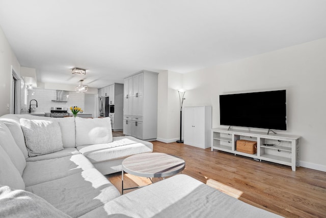 living area featuring baseboards and light wood finished floors