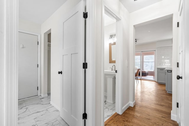 hallway featuring baseboards and marble finish floor