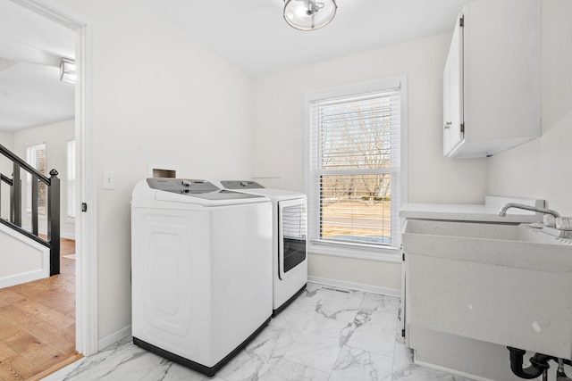 washroom with baseboards, cabinet space, marble finish floor, and washer and clothes dryer