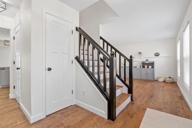 stairs featuring wood finished floors and baseboards