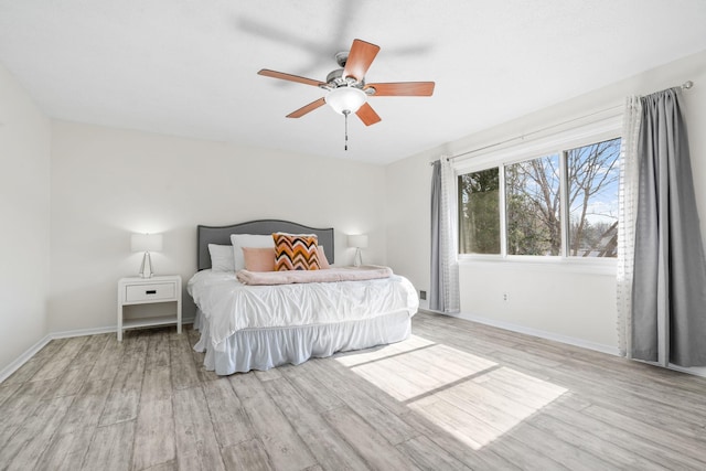 bedroom featuring a ceiling fan, baseboards, and wood finished floors