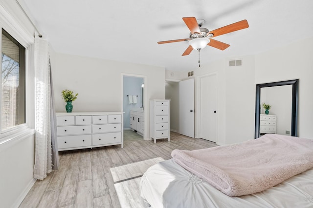 bedroom featuring visible vents, ceiling fan, ensuite bathroom, and light wood-style floors