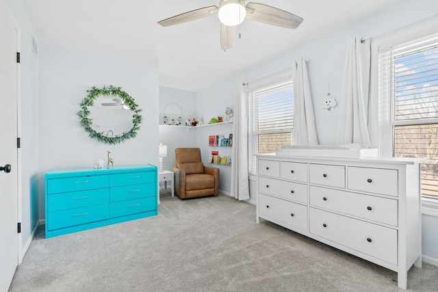 bedroom featuring baseboards, light colored carpet, and a ceiling fan