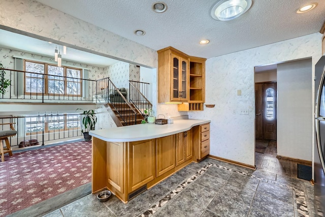 kitchen featuring a textured ceiling and kitchen peninsula