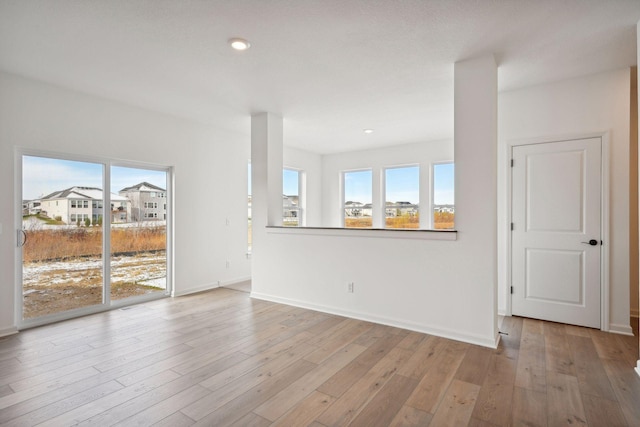 unfurnished living room with recessed lighting, baseboards, and wood finished floors