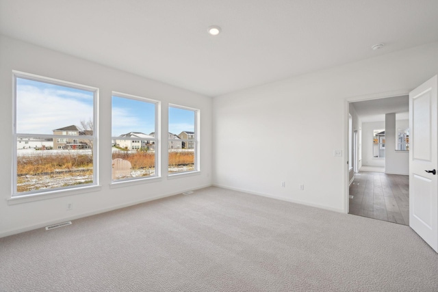 empty room with visible vents, baseboards, and carpet floors