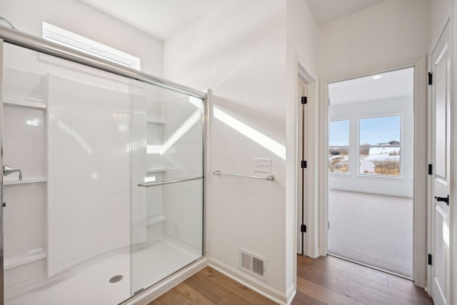 bathroom featuring visible vents, wood finished floors, and a stall shower