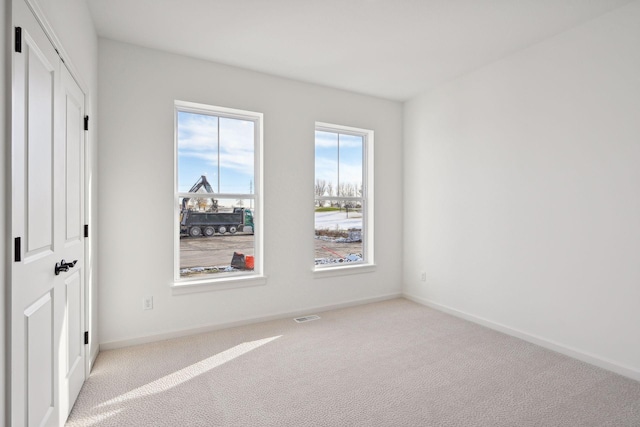 unfurnished bedroom with carpet flooring, baseboards, and visible vents