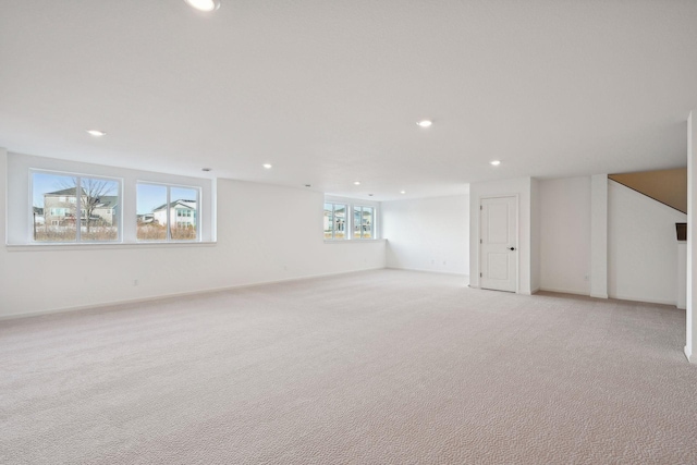 below grade area with recessed lighting, light colored carpet, and baseboards