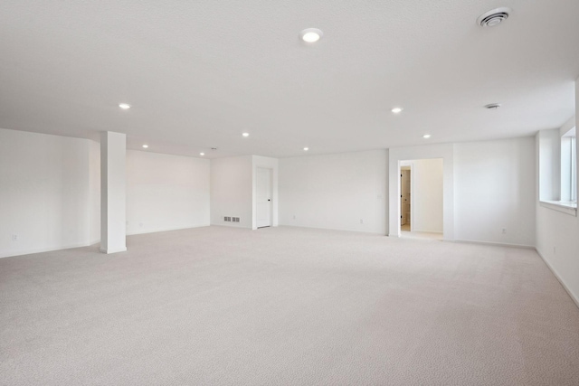 basement with light colored carpet, recessed lighting, and visible vents