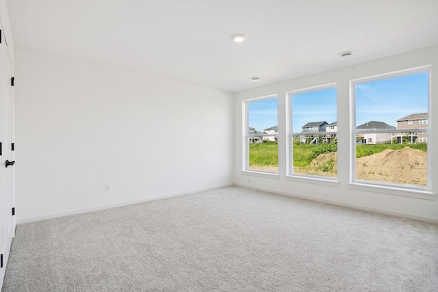 unfurnished room with baseboards and carpet