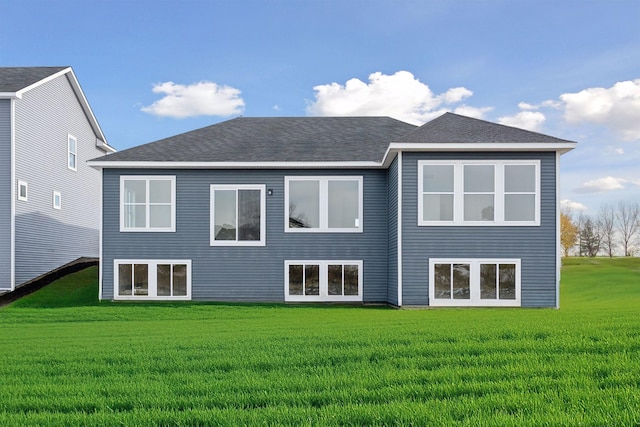 rear view of property with a lawn and a shingled roof