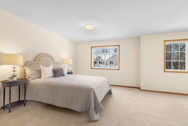 bedroom featuring multiple windows, light carpet, and a textured ceiling