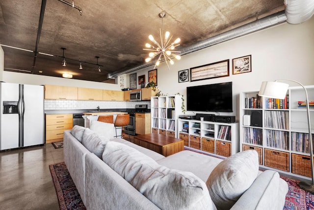 living area with concrete flooring and an inviting chandelier