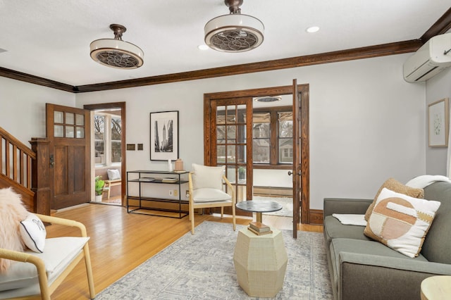 living room featuring crown molding, stairway, light wood-type flooring, and a wall mounted AC