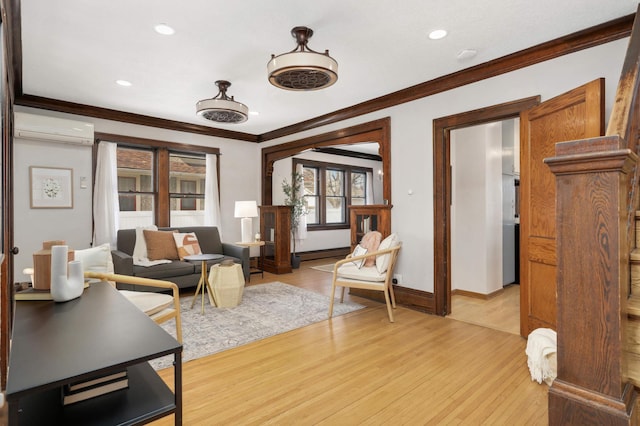 living area featuring baseboards, light wood finished floors, a wall mounted AC, ornamental molding, and a baseboard heating unit