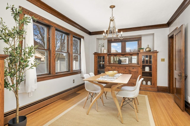 dining room with a notable chandelier, light wood-style flooring, ornamental molding, baseboards, and baseboard heating