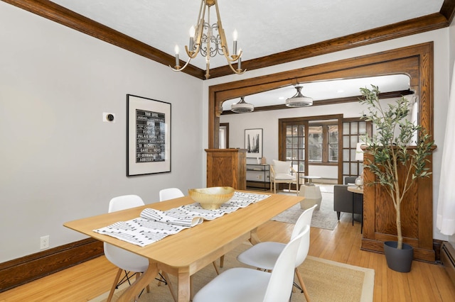 dining area with baseboards, wood finished floors, and crown molding