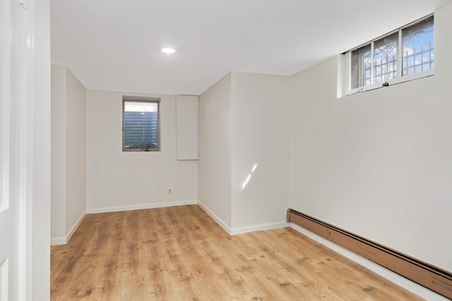 unfurnished room featuring light wood-style flooring, plenty of natural light, baseboards, and baseboard heating