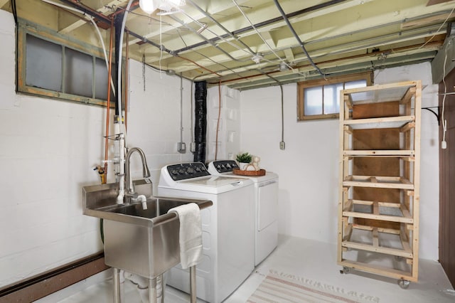 laundry room featuring washing machine and clothes dryer, laundry area, and a sink