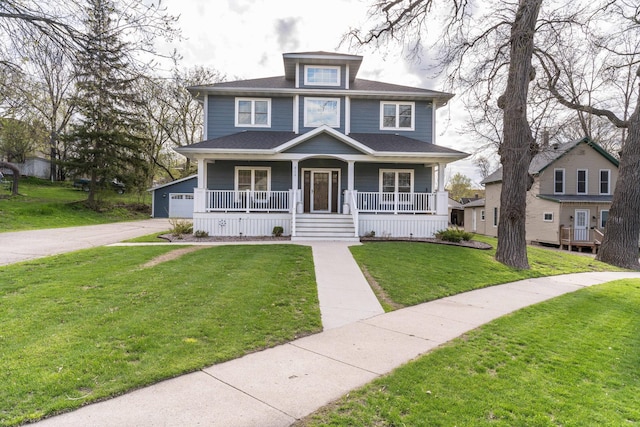 view of front of property featuring a garage, an outbuilding, a front lawn, and a porch