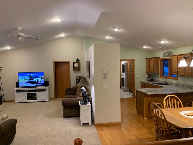 interior space with lofted ceiling, sink, ceiling fan, double wall oven, and kitchen peninsula