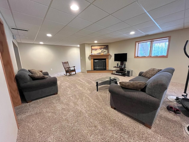 carpeted living area with a paneled ceiling, a glass covered fireplace, and recessed lighting