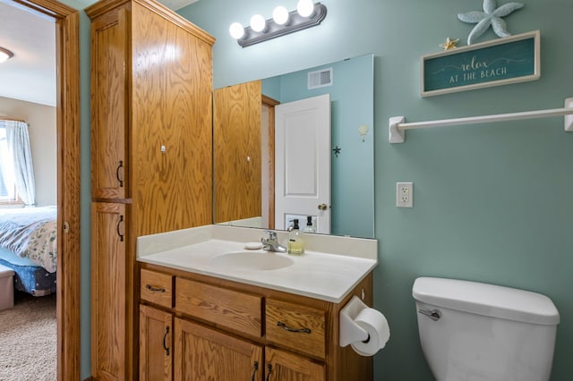bathroom featuring visible vents, connected bathroom, toilet, and vanity