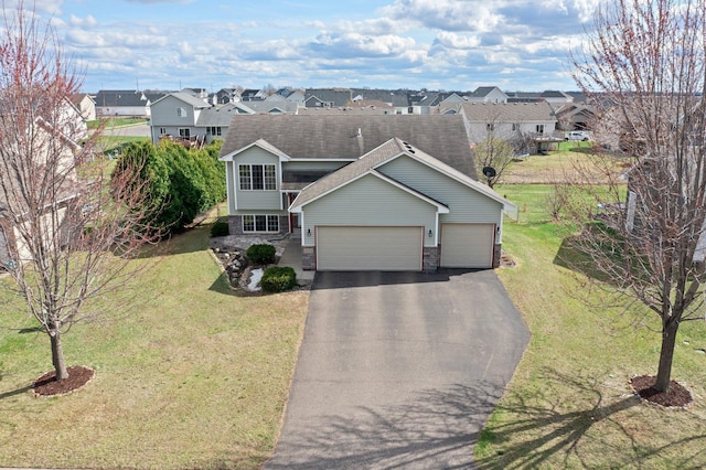 view of front facade with a garage, a front lawn, driveway, and a residential view