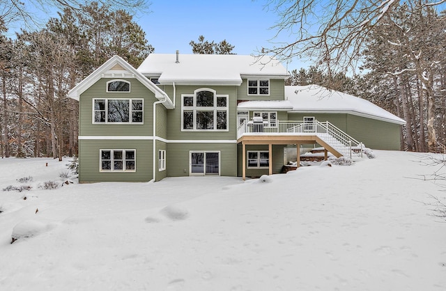 snow covered house with a wooden deck