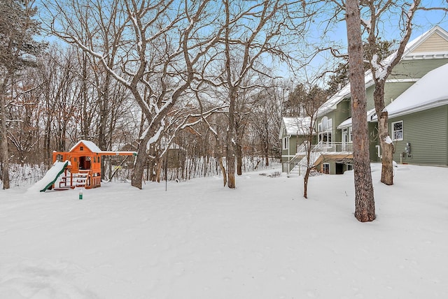 yard covered in snow with a playground