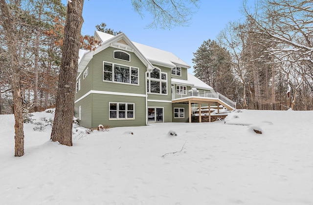 snow covered property with a wooden deck