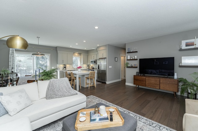 living area with recessed lighting, a textured ceiling, baseboards, and dark wood-style flooring