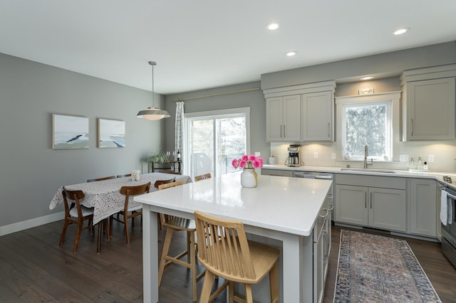 kitchen with a healthy amount of sunlight, dark wood-style floors, tasteful backsplash, and a sink