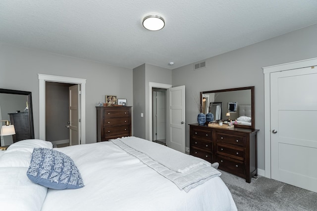 bedroom with visible vents, carpet floors, and a textured ceiling