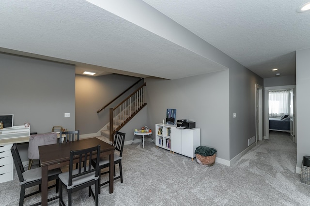 carpeted dining room with baseboards, a textured ceiling, and stairs