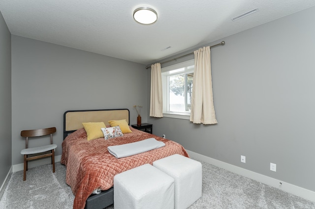 bedroom featuring baseboards, visible vents, carpet floors, and a textured ceiling