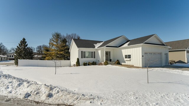 view of front of property featuring a garage, board and batten siding, and fence